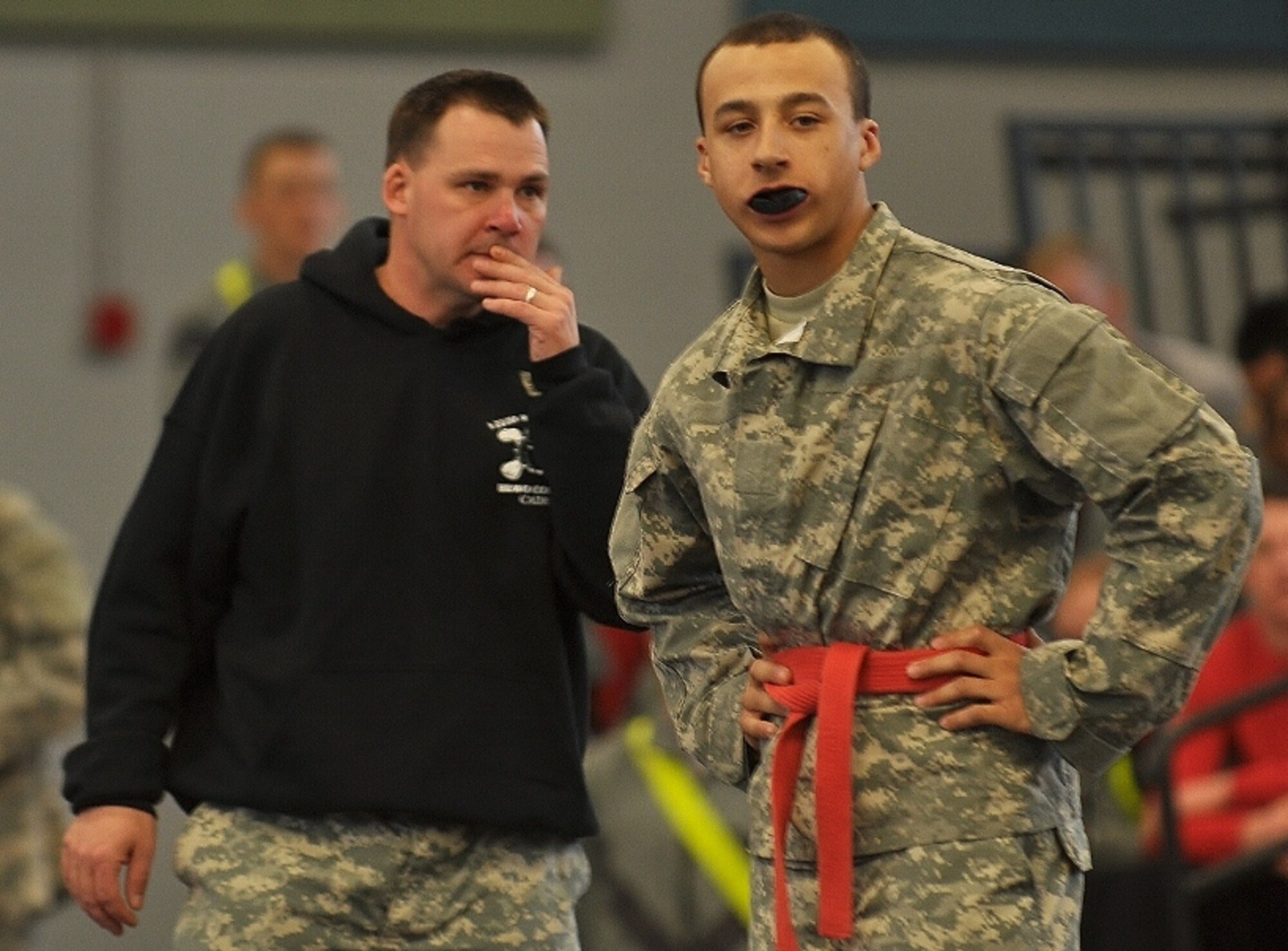 U.S. Army Pvt. Sergio McCluskey (right), assigned to B Company, listens to a trainer before a match during the 1st Battalion, 222nd Aviation Regiment's biannual combatives tournament at Anderson Field House at Fort Eustis, Va., Feb. 23, 2013. McCluskey moved through the bracket and won the lightweight class final at the competition. (U.S. Air Force photo by Senior Airman Jason J. Brown/Released)