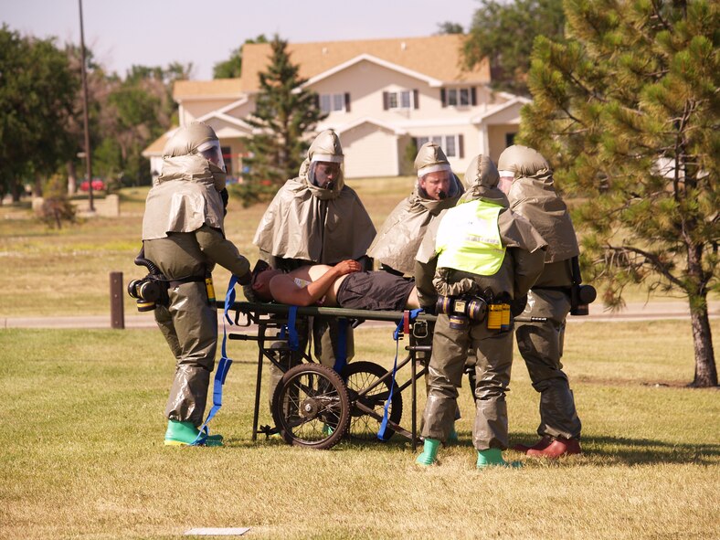 Medical Group manpower team retrievea an exercise patient from the field for processing through In-Place Patient Decontamination.