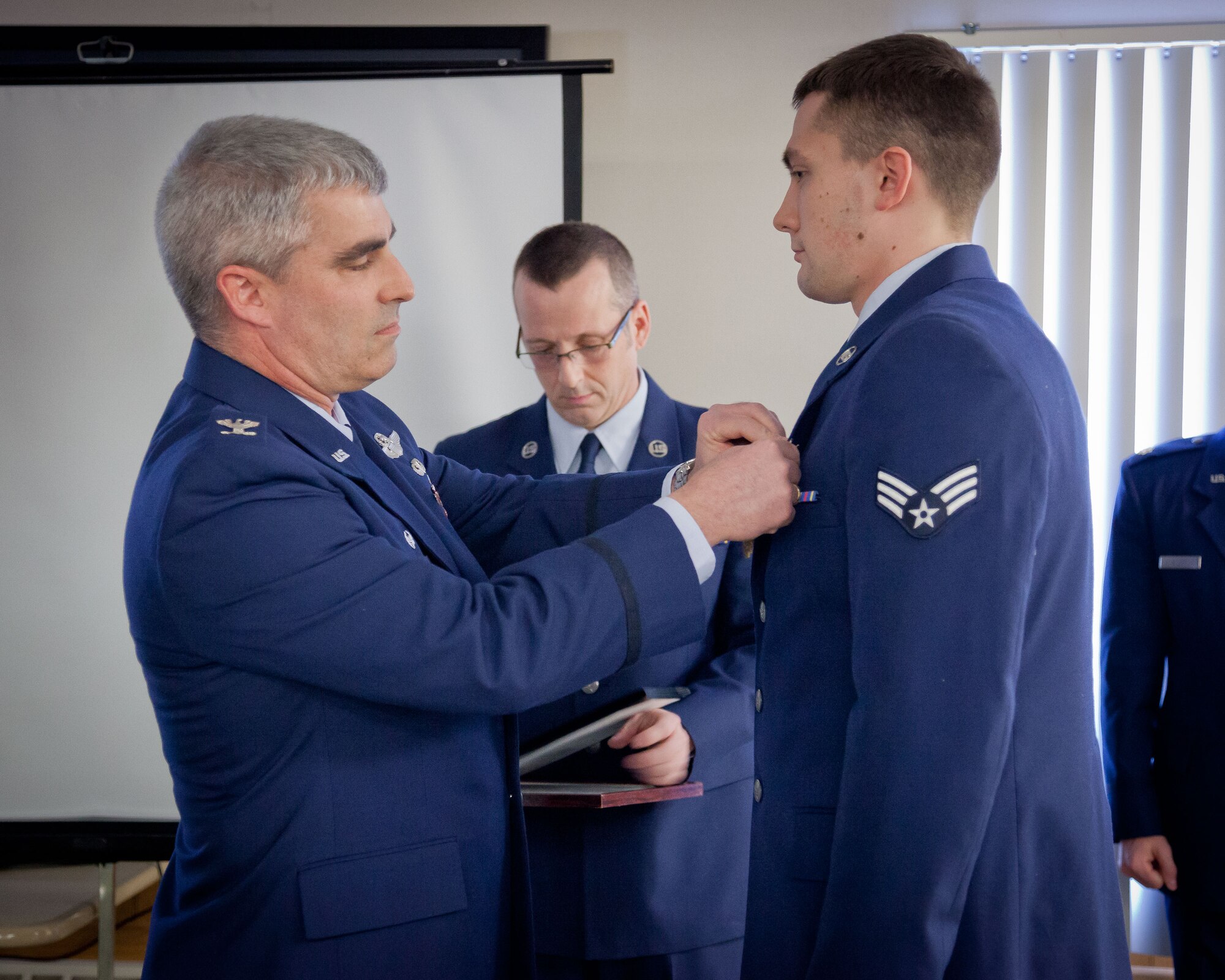 Col. Keith T. Wesley, 934th Operations Group commander, presents Senior Airman Jackson D. Norman with the Air Medal during the group's Commander's Call during the March Unit Training Assembly.  (U.S. Air Force photo/Shannon McKay)