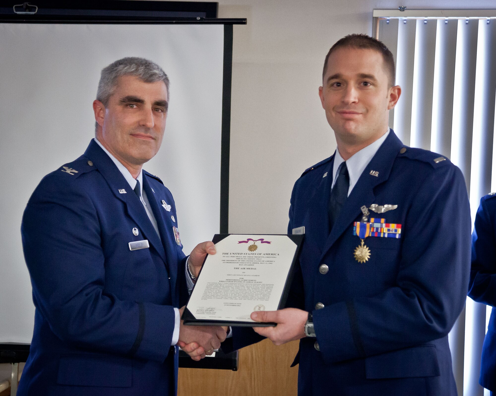 Col. Keith T. Wesley, 934th Operations Group commander, presents 1st Lt. Ryan E. Leadens with the Air Medal during the group's Commander's Call during the March Unit Training Assembly.  (U.S. Air Force photo/Shannon McKay)