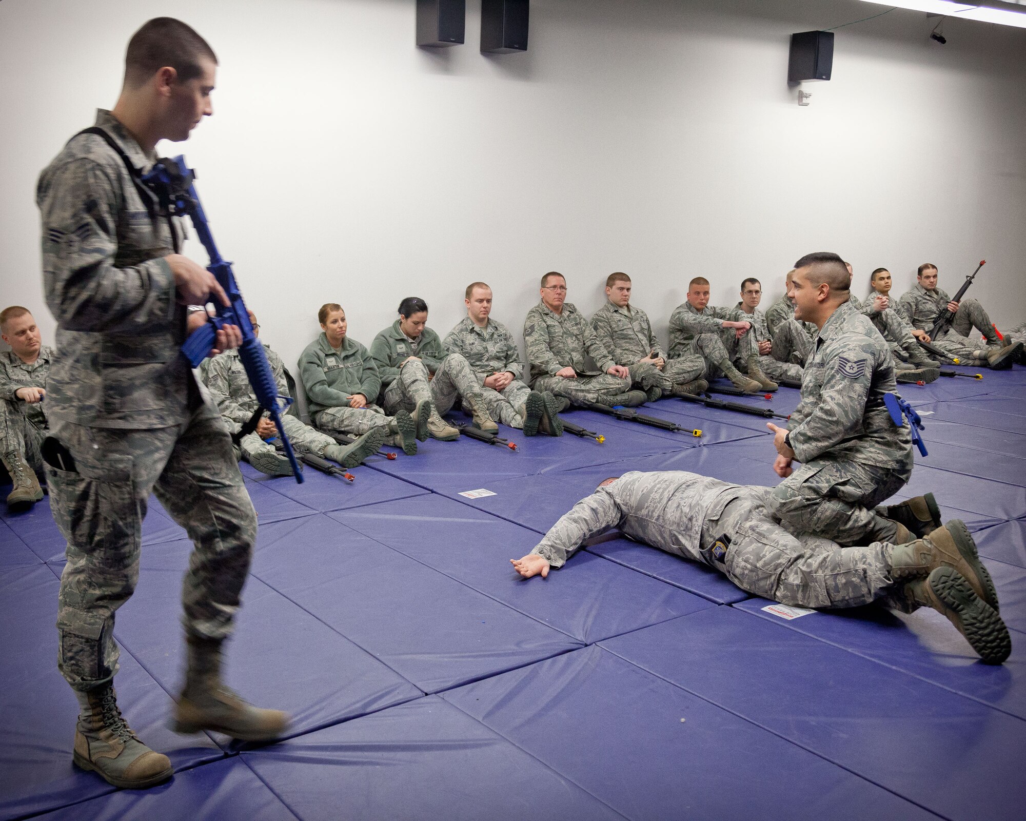 Tech. Sgt. Ryan St. John and Senior Airman Patrick McCarthy, 934th Security Forces Squadron, demonstrate how to secure a suspect to members of the 934th Airlift Wing.  The weapons issue and clearing training class was held in preparation for the upcoming Operations Readiness Exercise in April.  (U.S. Air Force photo/Shannon McKay)
