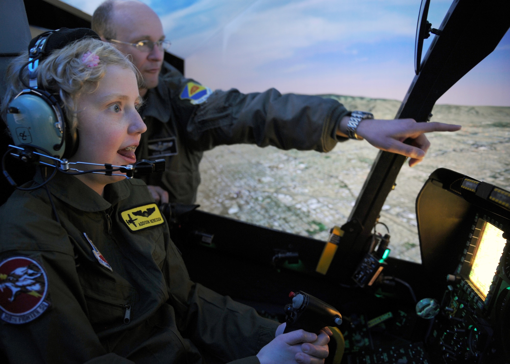 Addison Rerecich, a 13-year-old Tucsonan recovering from a double lung transplant, flies the A-10 Thunderbolt II simulator with help from U.S. Air Force Maj. Michael McKee, 358th Fighter Squadron pilot, during her tour of Davis-Monthan Air Force Base, Ariz. Feb. 21, 2013, as the Pilot for a Day participant. The D-M Pilot for a Day program invites children with serious or chronic conditions, to be a guest of the 355th Fighter Wing and one of the flying squadrons for an entire day. (U.S. Air Force photo by Senior Airman Brittany Dowdle)