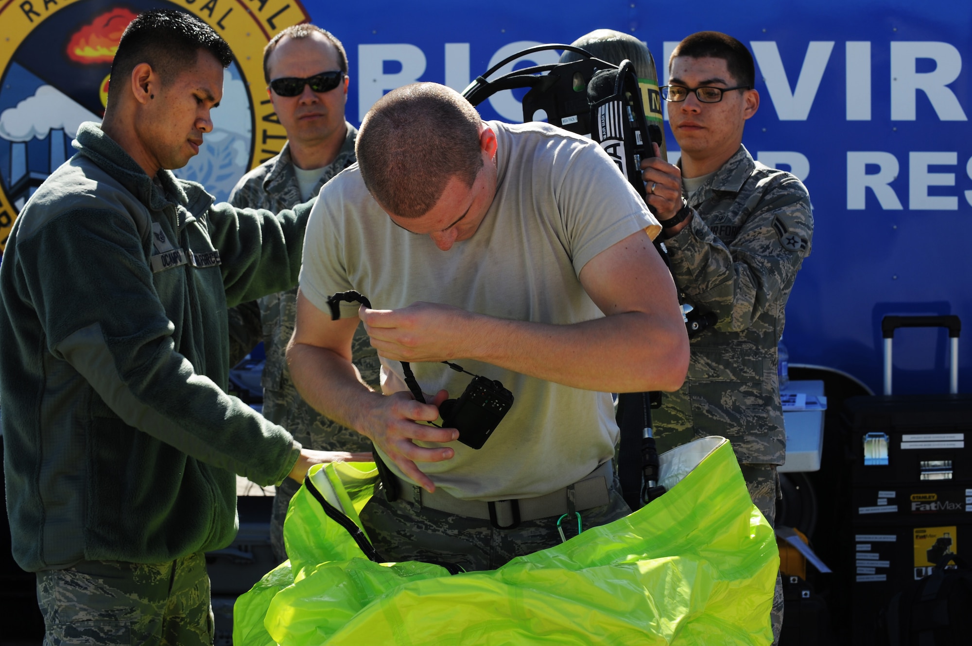 Staff Sgt. Joseph Ocampo, 99th Medical Group Squadron non-commissioned officer in charge of readiness, and Airman 1st Class Joshua Arteaga, 99th Medical Group bioenvironmental engineer apprentice, assist Senior Airman Nichalos Johnson, 99th Medical Group bioenvironmental engineer journeyman, out of a fully encapsulating protective suit Feb. 28, 2013 at Nellis Air Force Base, Nev. The protective suit is equipped with a Self Contained Breathing Apparatus that allows personnel to breathe clean air while in chemical environments. (U.S. Air Force photo by Staff Sgt. William P. Coleman)
  

