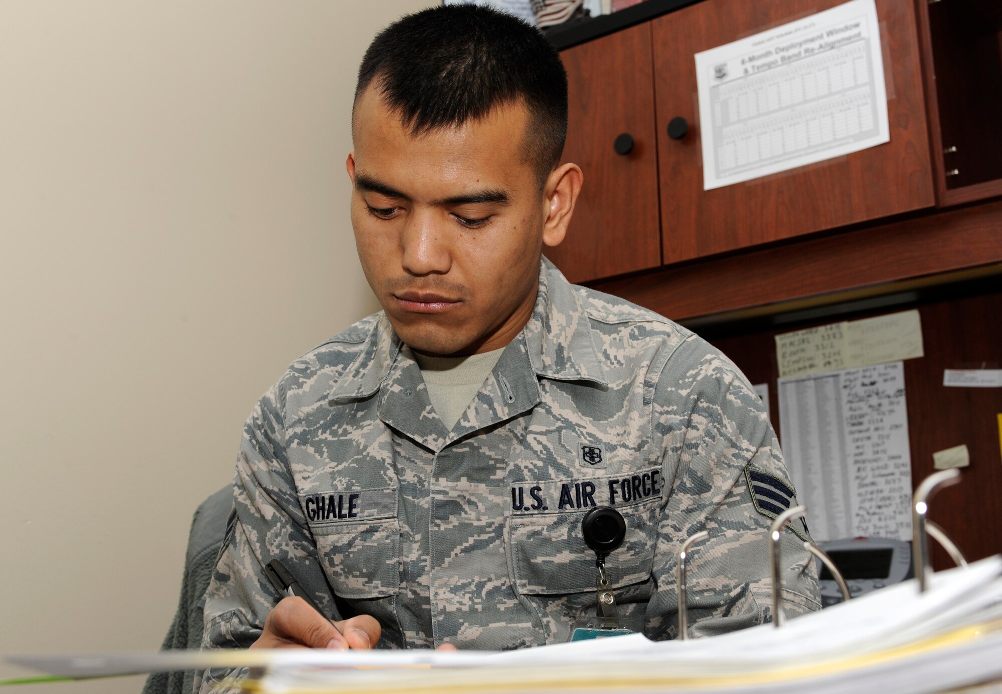 Senior Airman Tilli Ghale, 28th Medical Group unit deployment manager, updates a deployment checklist in a continuity binder at the 28th MDG on Ellsworth Air Force Base, S.D., March 4, 2013. Ghale received a 94 percent on his "Health Services Management" five-level Career Development Course – the highest score in the Air Force for that particular CDC in three years. (U.S. Air Force photo by Airman 1st Class Ashley J. Thum/Released)