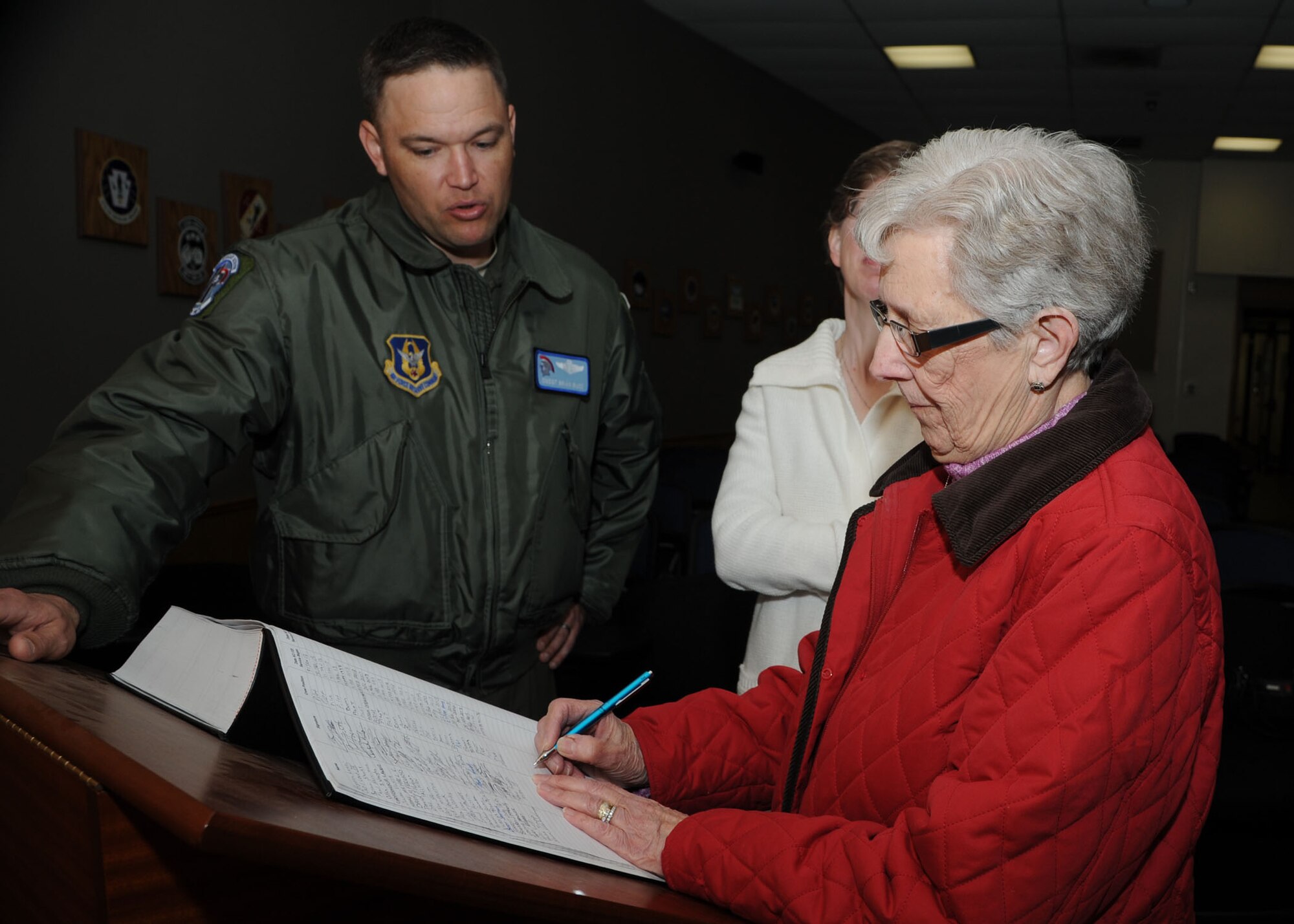 ALTUS AIR FORCE BASE, Okla. – Chief Master Sgt. Brian Buss, 730th Air Mobility Training Squadron superintendent, watches as Luella Klaverkamp, mother of late KC-135 Stratotanker boom operator, Airman 1st Class Bruce Klaverkamp, signs the Altus AFB boom operator Legacy Book at the Holsey Auditorium, March 3, 2013. Bruce died in a plane crash, March 13, 1972, during a routine training mission at Carswell AFB, Texas. The Legacy Book is signed by every boom operator and pilot who worked on KC-135 aircraft. (U.S. Air Force photo by Airman 1st Class Klynne Pearl Serrano / Released)