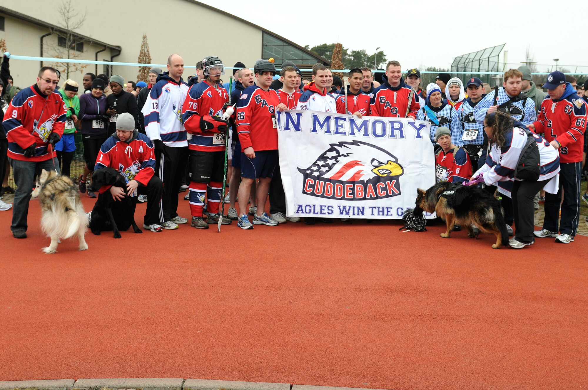 Members of the Kaiserslautern Military Community Eagles hockey team pose for a group photo before the start of the second annual Airman 1st Class Zachary Ryan Cuddeback Memorial 5K on Ramstein Air Base, Germany, March 2, 2013. Members of the 86th Vehicle Readiness Squadron hold the run in honor of their fallen comrade A1C Zachary Ryan Cuddeback. (U.S. Air Force photo/Airman 1st Class Holly Cook)