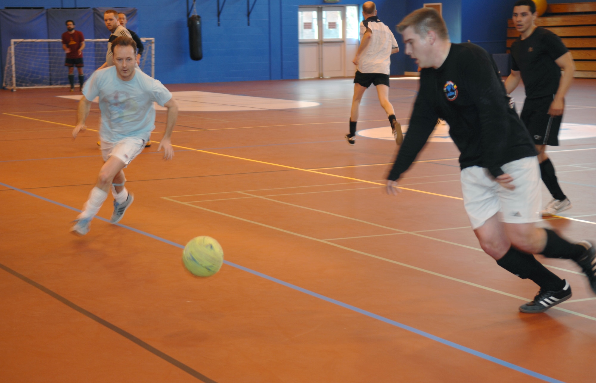 From left, Steve Bain, 100th Force Support Squadron information technology cyber systems manager, competes for the ball with Tech. Sgt. Christopher Klare, 488th Intelligence Squadron NCO in charge of training and evaluation, during an indoor soccer match March 5, 2013, at the Northside Fitness Center, RAF Mildenhall, England. The 100th FSS defeated the 95th Reconnaissance Squadron/488th IS 3-2. (U.S. Air Force photo by Airman 1st Class Dillon Johnston/Released)