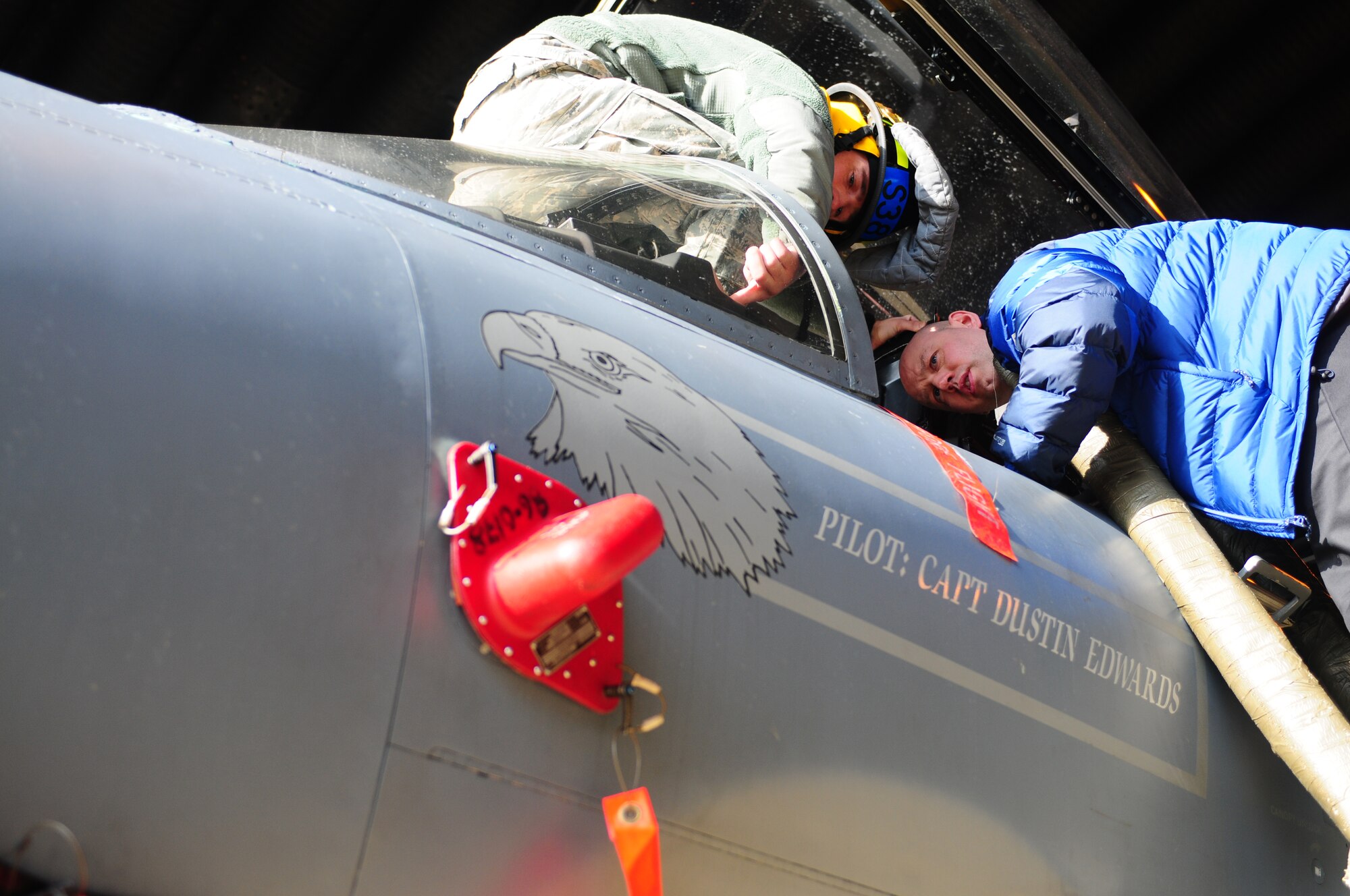 ROYAL AIR FORCE LAKENHEATH, England -- Senior Airman Brandon Smart, 48th Civil Engineer Squadron firefighter, explains emergency aircrew extraction techniques to James Hilton, Norfolk Fire and Rescue Service crew manager March 5, 2013. The Norfolk Fire and Rescue Service brigade received training on aircraft safety specific to firefighters such as engine shut down and pilot egress. (U.S. Air Force photo by Airman 1st Class Dana J. Butler)