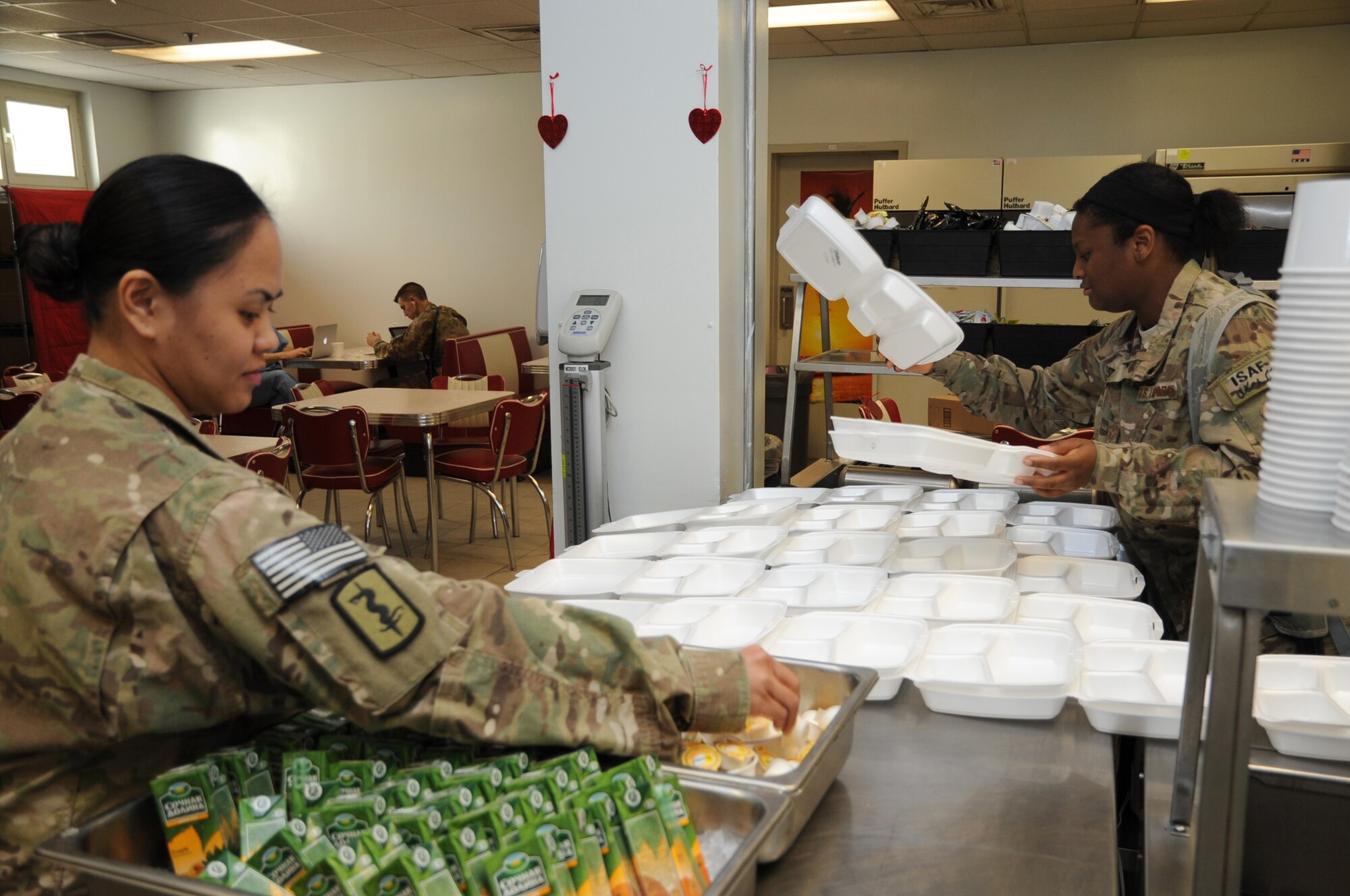 Tech. Sgt. Liezel Huynh, 455th Expeditionary Medical Support Squadron nutritional medicine flight chief (left), and Staff Sgt. Nicole Kilson, 455th EMDSS diet therapy technician, prepare for the lunch rush at the Craig Joint Theater Hospital cafeteria on Bagram Airfield, Afghanistan, March 5, 2013. The nutritional medicine flight serves more than 8,000 meals a month. (U.S. Air Force photo/Staff Sgt. David Dobrydney)