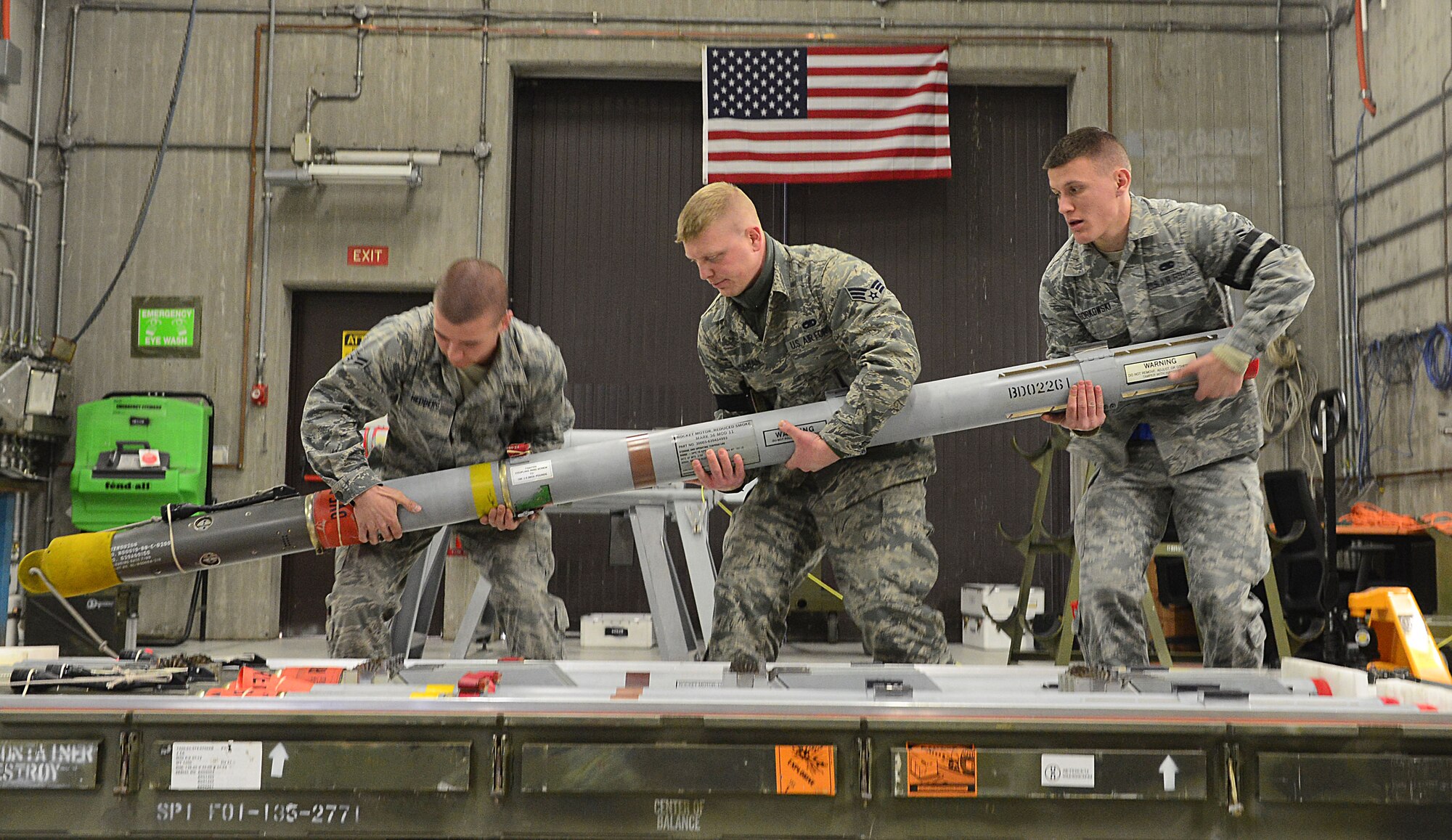 (From left) Airman 1st Class Cody Hedberg, Senior Airman Michael Bingaman and Airman 1st Class Phillip Borkowski, 31st Munitions Squadron precision guided munitions crew members, picks up an AIM-9/M missile to inspect, Feb. 26, 2013 at Aviano Air Base, Italy. Under the 31st MUNS, there are six different flights that provide armament, production, materiel, weapons, systems and programs for the 510th and 555th Fighter squadrons and the 31st Security Forces Squadron. (U.S. Air Force photo/Airman 1st Class Matthew Lotz)
