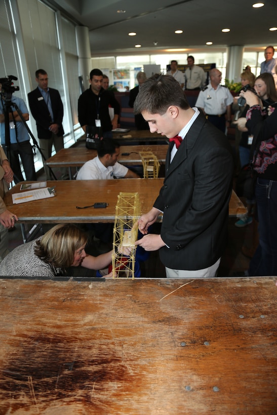 Peter House, of the Thunder Buddies from Bishop Kenny High School prepares the bridge he made with teammates Stephen Baltz, Michael Barr and Zach McNulty to be tested by the weight of sand. The Thunder Buddies were overall winners for Engineering Career Day 2013. 