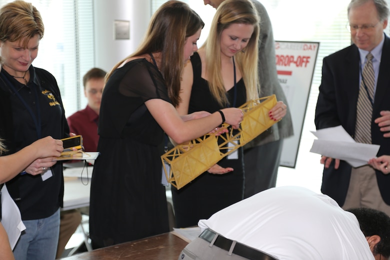 Savannah Shelton (left) and Rebecca Wright of Yulee High School’s all-girl team, The Plastics, check over their bridge after placing third in the Take Home Project part of the Engineering Career Day competition. 