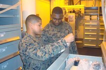 Pfc. Mariko N. Johnson (left), a Hubert, N.C., native and a general accounts clerk, and Pfc. Christian D. Durrah, a Spartanburg, S.C., native and a shipping and receiving clerk, both with 2nd Supply Battalion, 2nd Marine Logistics Group, sort through gear during a replenishment deployment aboard the USNS Robert E. Peary from Feb. 7 to 17, 2013.  A detachment of four Marines from 2nd Supply Bn. utilized a new supply system through the Navy.                                