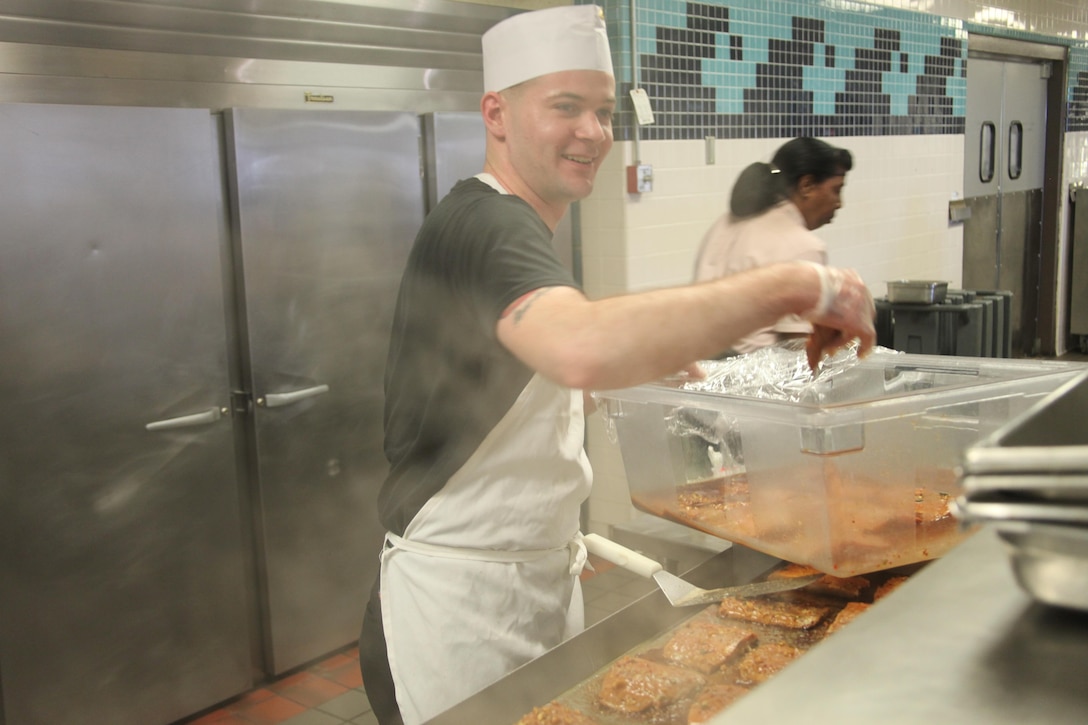 Lance Cpl. Timothy J. Bruce, a food service specialist with Headquarters and Headquarters Squadron, puts his rendition of sweet and spicy salmon on the grill just minutes before the Chef of the Quarter competition at the Marine Corps Air Station Cherry Point Mess Hall Friday. Normally, the chefs have a few weeks to prepare a tasting menu, practice preparation of their dishes and put the finishing touches on their creations. Due to last-minute circumstances, Bruce stood in for a fellow Marine with only 12 hours notice to prepare for the competition.

