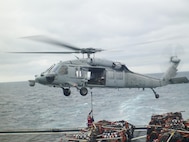 A naval aircraft assists a detachment of Marines from 2nd Supply Battalion, 2nd Marine Logistics Group to replenish the 26th Marine Expeditionary Unit. The detachment of four Marines aboard the USNS Robert E. Peary utilized a new supply system through the Navy from Feb. 7 to 17, 2013. 