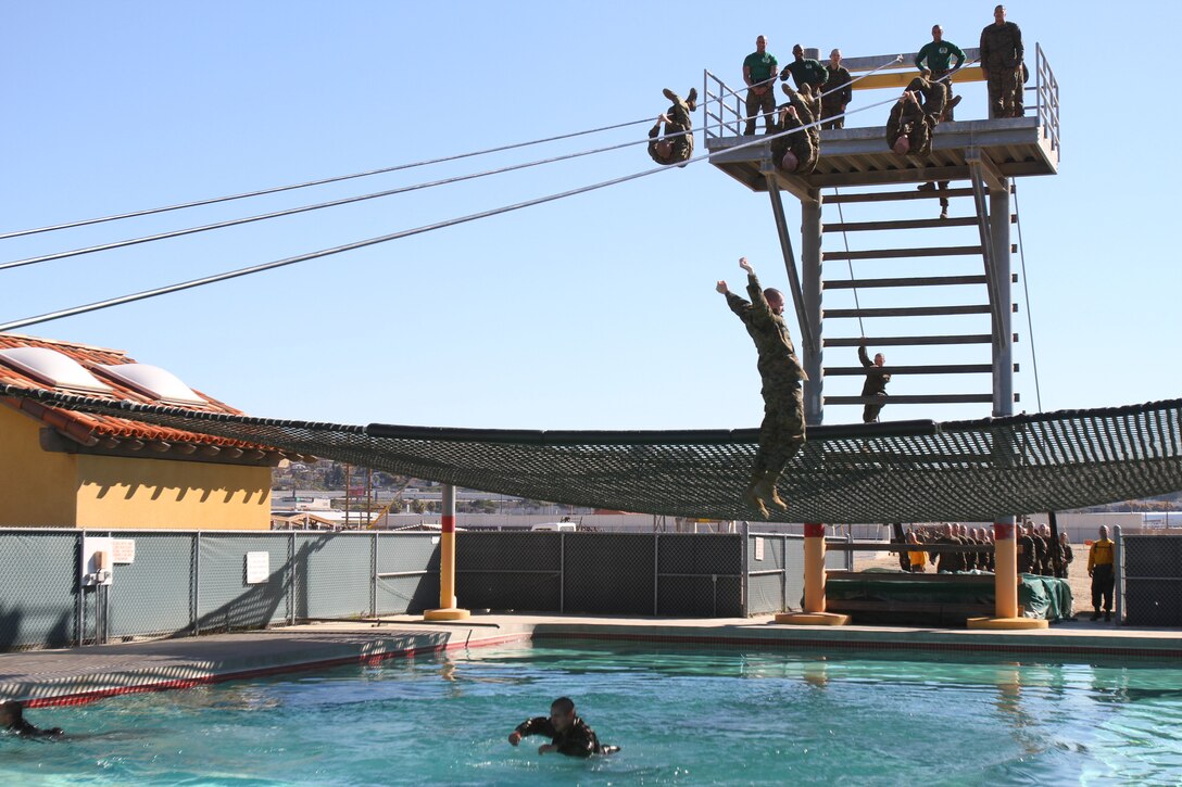 A recruit of Company E, 2nd Recruit Training Battalion, falls into the pool during the Confidence Course aboard Marine Corps Recruit Depot San Diego Feb. 26. Recruits must slide down the rope using proper technique or they will fall into the pool.