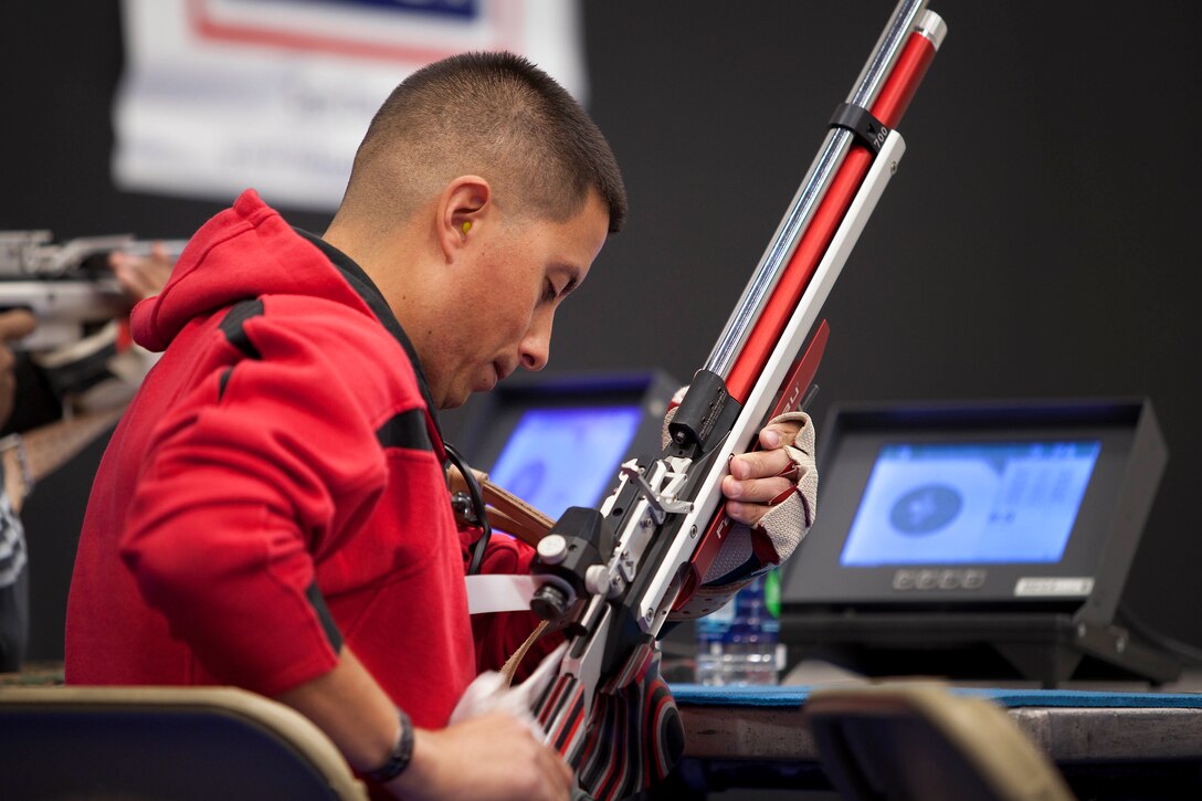 Sgt. Anthony A. Arriaga, an athlete with Team West, wipes his weapon during the Marine Corps Trial’s shooting competition here March 4.