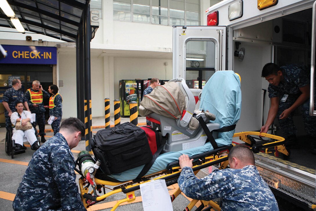 Sailors practice loading simulated patients into an ambulance March 2 as part of a patient relocation drill at U.S. Naval Hospital Okinawa transported Camp Lester. The purpose of the drill was to ensure the safety and comfort of patients being transported from Camp Lester to Camp Foster while they are under the care of USNH Okinawa during thr transition to the new facility. The sailors are corpmen with USNH Okinawa.