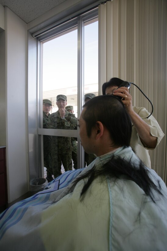 A Japan Ground Self Defense Force soldier receives a haircut at the northside barbershop during a recent visit to Marine Corps Air Station Iwakuni, Japan, Feb. 28, 2013. Two JGSDF soldiers opted to get an authentic Marine Corps haircut, a high and tight, during the three-day visit.