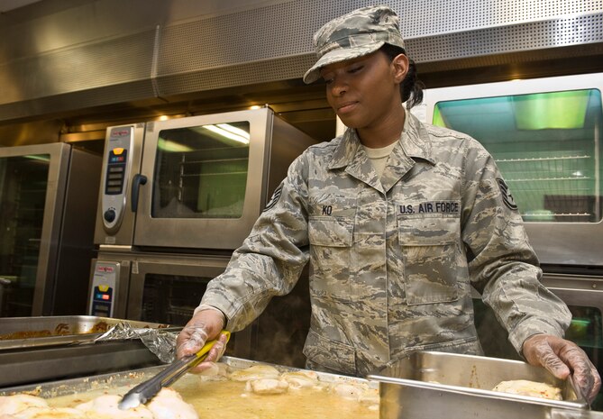 U.S. Air Force Staff Sgt. Sherisha Ko, 99th Force Support Squadron food service shift leader, transfers grilled chicken to a pan March 6, 2013, at Nellis Air Force Base, Nev. Ko is responsible for planning, preparing and adjusting menu items at the Crosswinds Dining Facility. (U.S. Air Force photo by Senior Airman Matthew Lancaster)