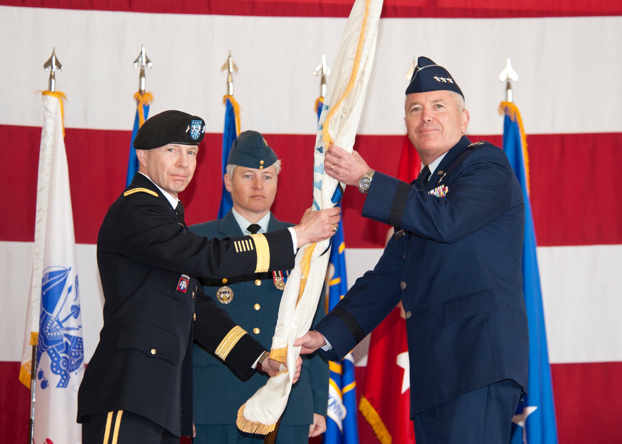 U.S. Air Force Lt. Gen. William H. Etter, passes the Continental U.S. North American Aerospace Defense Command Region flag to U.S. Army Gen. Charles H. Jacoby, NORAD commander, during the Continental U.S. North American Aerospace Defense Command Region-1st Air Force (Air Forces Northern) change of command ceremony at Tyndall Air Force Base, Fla., Mar. 7. Etter assumed command from Lt. Gen. Stanley E. Clarke.  (U.S. Air Force photo by Lisa Norman)