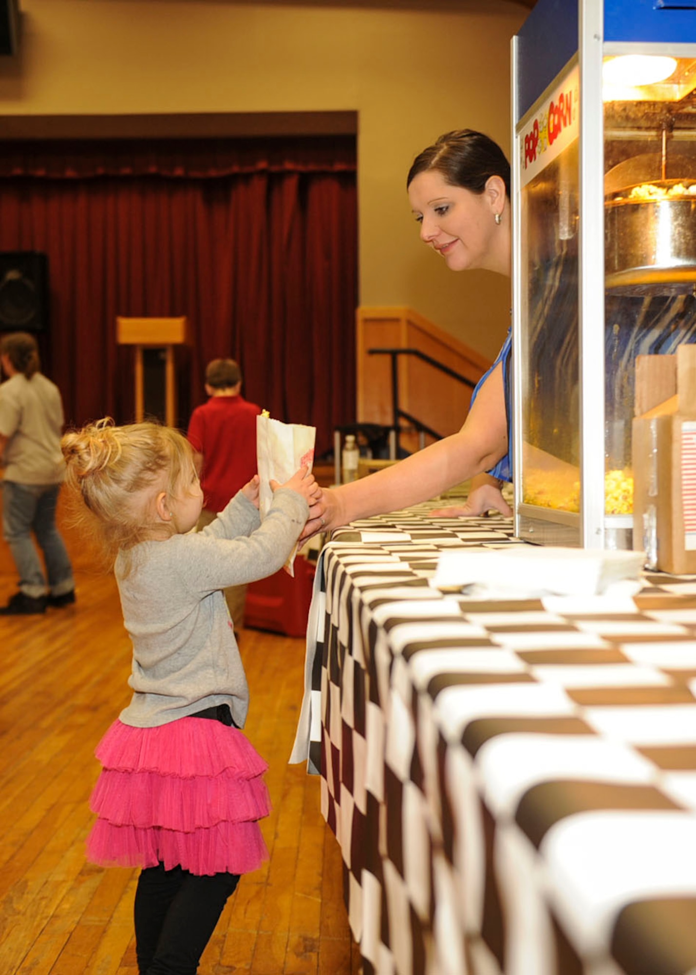 A child is handed a bag of popcorn during the Radio Disney performance Feb. 28, 2013, at Little Rock Air Force Base’s Thomas Community and Activities Center. Along with the Radio Disney performance, there was a bounce castle and a Just Dance competition. (U.S. Air Force photo by Airman 1st Class Cliffton Dolezal)
