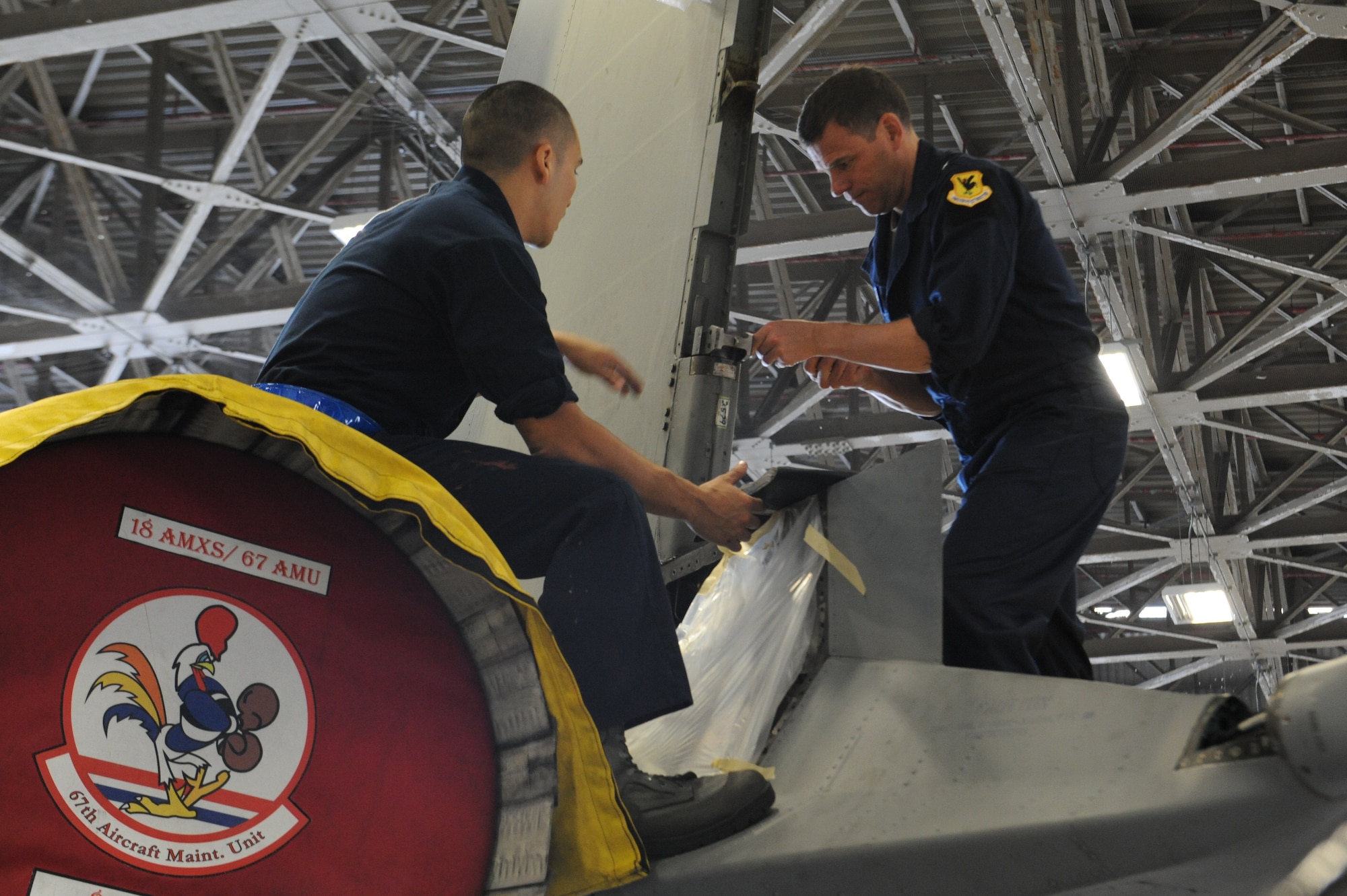 U.S. Air Force Brig. Gen. Matt Molloy, 18th Wing commander, and Senior Airman Nicholas Caudillo, 18th Equipment Maintenance Squadron phase dock F-15 crew chief, twist screws into the tail of an F-15 Eagle fighter aircraft on Kadena Air Base, Japan, March 7, 2013. Molloy visited the squadron to experience what the Airmen do on a day-to-day basis in their career field. (U.S. Air Force photo/Airman 1st Class Malia Jenkins)