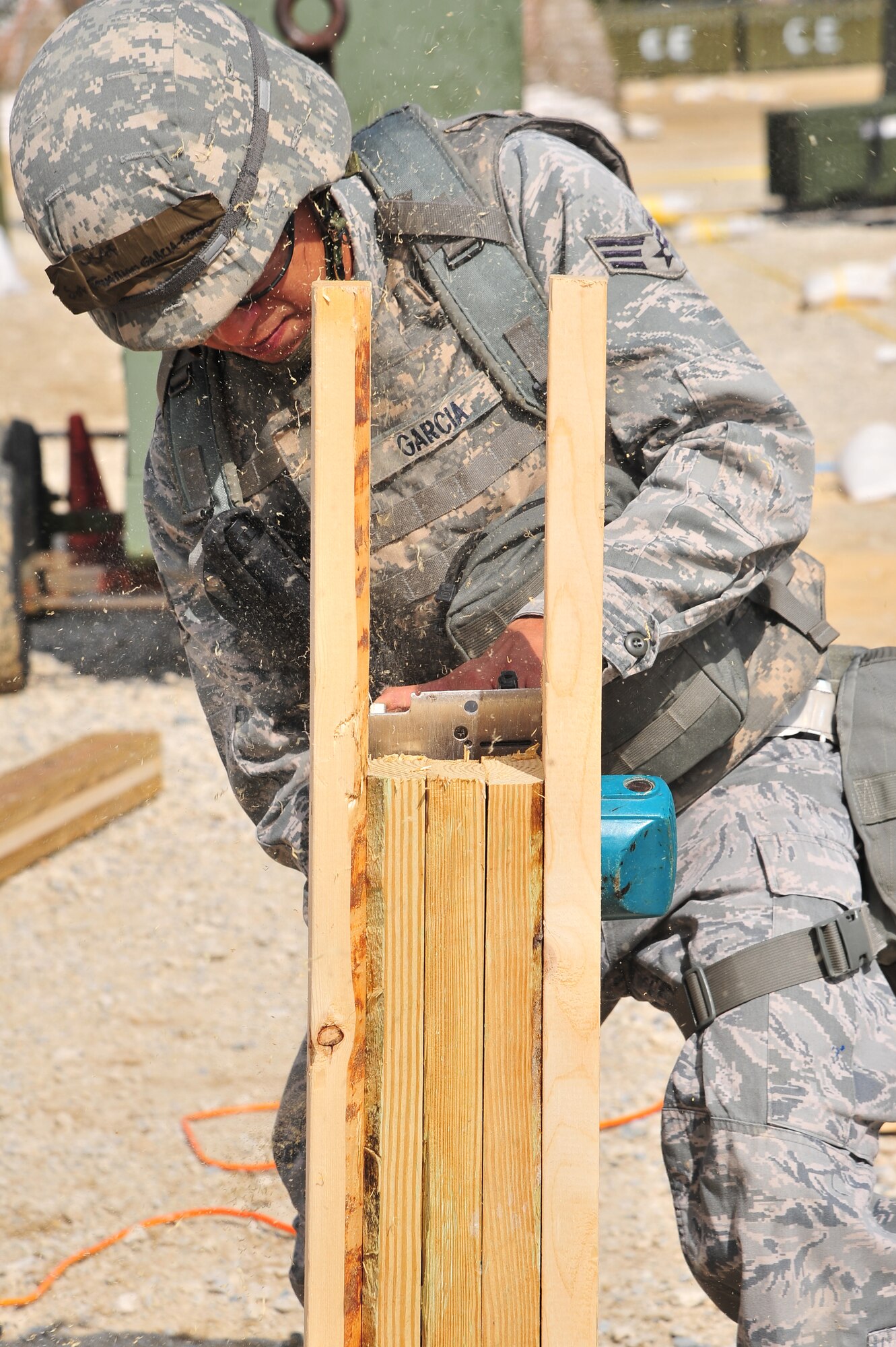 U.S. Air Force Senior Airman Jonathan Garcia, 4th Civil Engineer Squadron structural technician, saws through wood during Operational Readiness Inspection CORONET WHITE at a simulated deployed location on Seymour Johnson Air Force Base, N.C., Mar. 7, 2013. Garcia built a new drop-arm, which will be used as a replacement at an alternate entry control point. (U.S. Air Force photo/Airman 1st Class Aubrey White/Released)