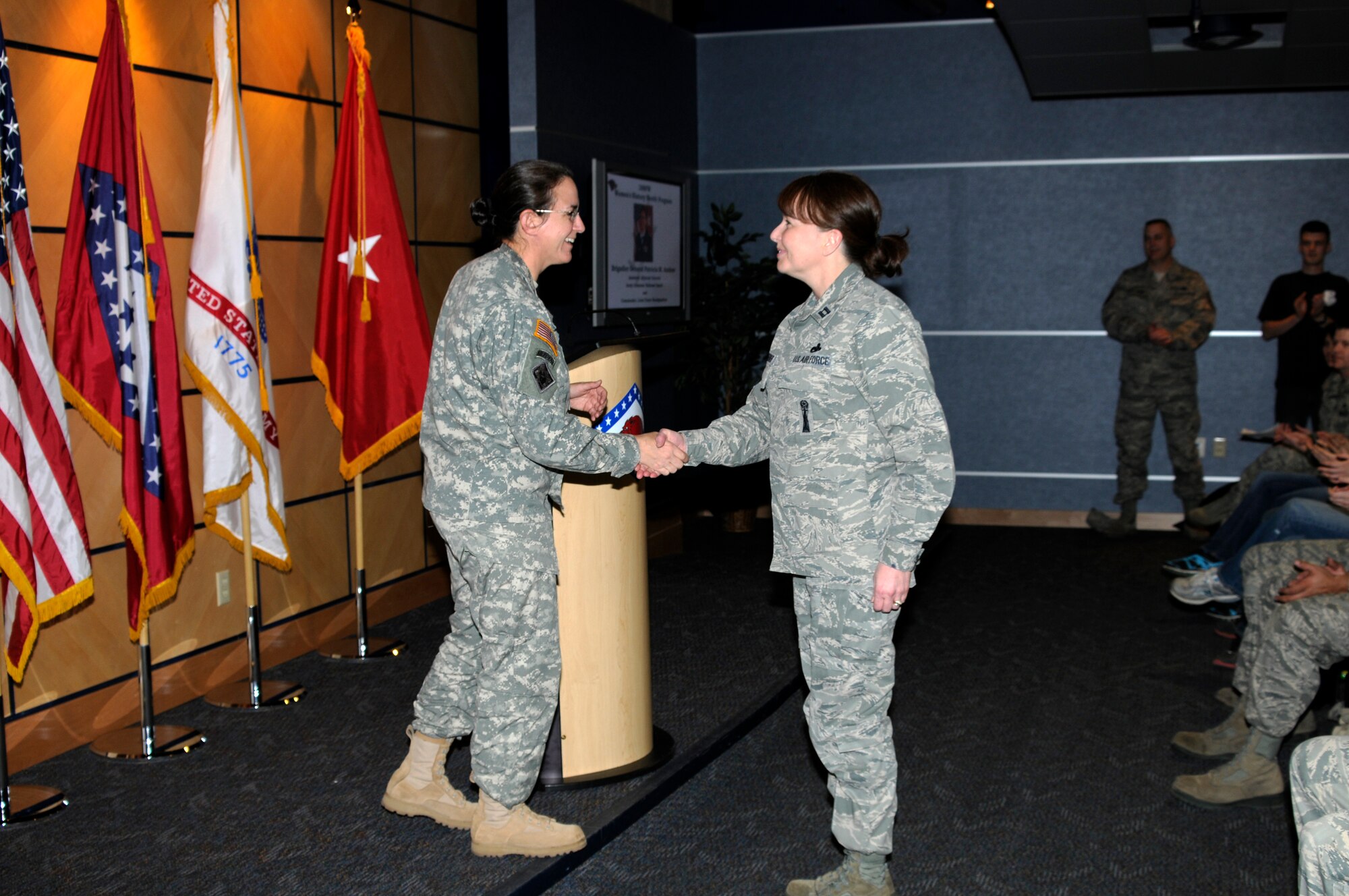 Brig. Gen. Patricia M. Anslow shakes hands with Capt. Kim Sosebee during a Women's History Month program March 2, 2013, at the 188th Fighter Wing during. Anslow is the first female general officer in the Arkansas National Guard. (National Guard photo by 1st Lt. Holli Snyder/188th Fighter Wing Public Affairs)