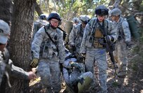 Staff Sgt. Craig Davis, noncommissioned officer in charge of pass and registration for the 18th Security Forces Squadron, is carried on a litter in order to get him to a combat medical aid station as a result of mock injuries during the training. Davis spent 26 days in February attending the Combat Leadership Course, Level II, at Joint Base San Antonio-Camp Bullis, Texas. He and 42 Security Forces Airmen spent the six weeks learning Security Forces operations and practical field skills such as moving as teams and squads, as well as conducting missions in the field. The course is taught several times during the year through the Security Forces Academy, part of the 343rd Training Squadron at JBSA-Lackland. (U.S. Air Force photo by Senior Airman Matthew Fredericks/Released)