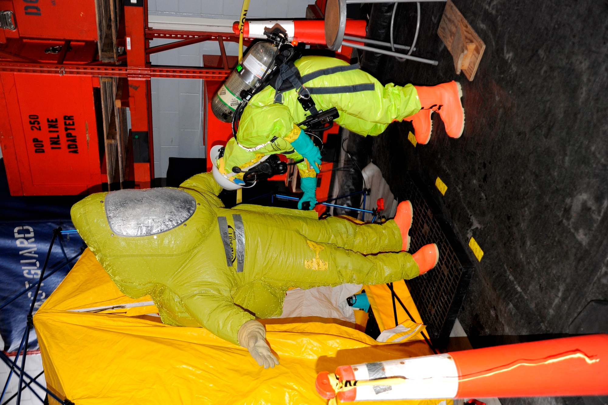 Coast Guard Petty Officer 1st Class Ken Cook, Atlantic Strike Team boatswain’s mate, is checked for contaminates by Petty Officer 2nd Class Maria Sabat, AST storekeeper,  during a training event Feb. 28, 2013, at a simulated decontamination site at a AST facility on Joint Base McGuire-Dix-Lakehurst, N.J. The training event covered responding to a simulated hazardous material cleanup, with entry and decontamination teams in full protective posture equipment. (U.S. Air Force photo by Pascual Flores/Released)