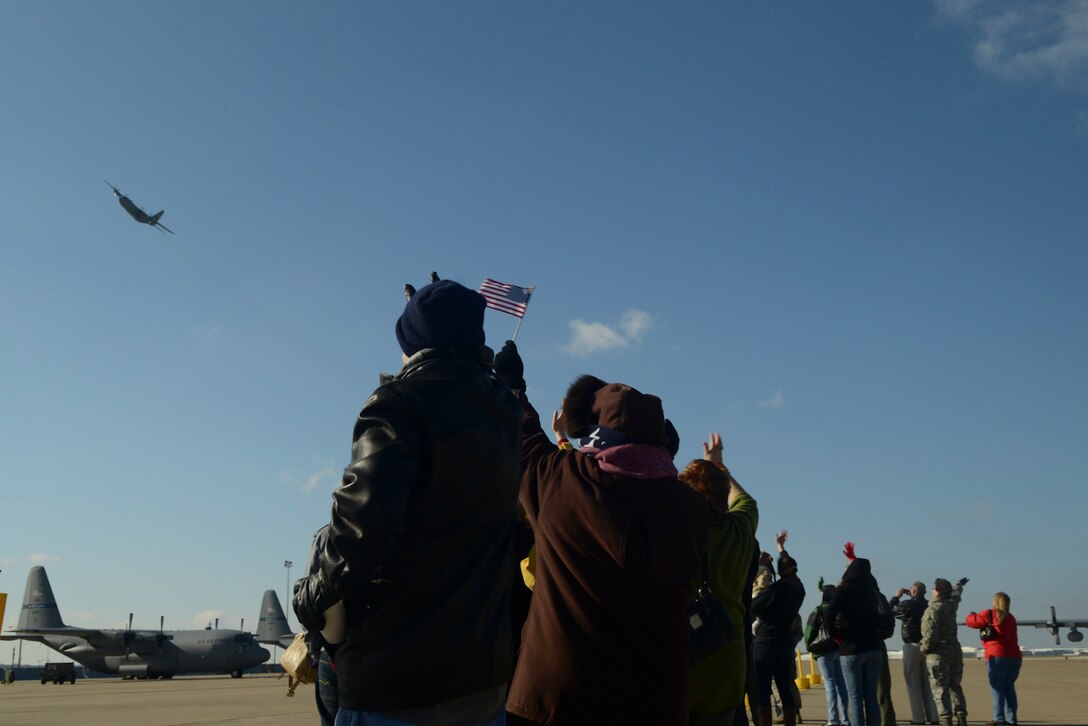 Friends and family of the 136th Airlift Wing wave at the C-130 aircraft as it flies by prior to departing for Southwest Asia at NAS Fort Worth JRB, Texas, Feb. 26, 2013. The Airmen will support the Air Expeditionary Forces in Southwest Asia from 60 to 180 days.. (National Guard photos by Senior Master Sgt. Elizabeth Gilbert)