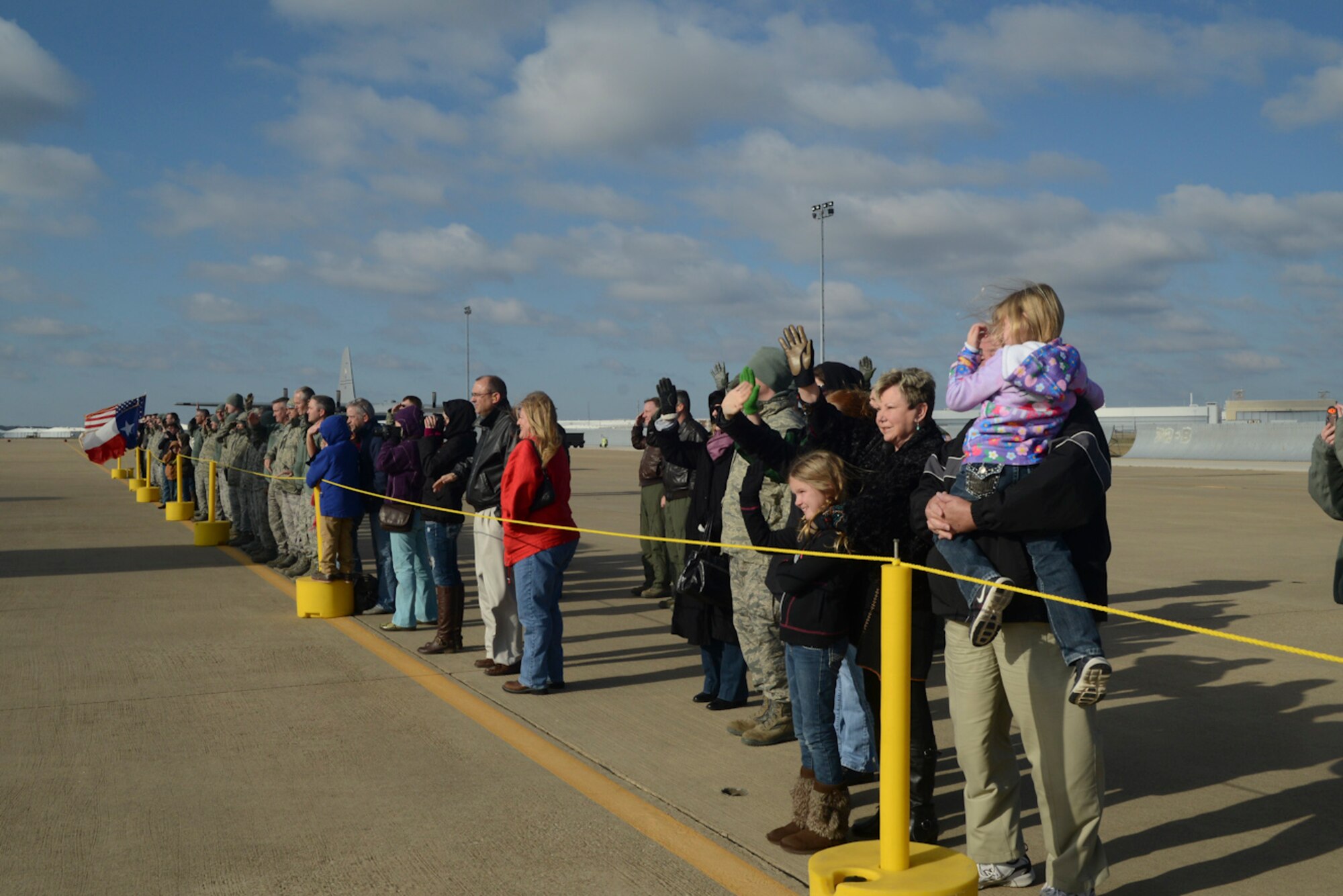 Friends and families wave good bye to the taxiing C-130 aircraft carrying their love ones on board for Southwest Asia at NAS Fort Worth JRB, Texas, Feb. 26, 2013. The Airmen will support the Air Expeditionary Forces in Southwest Asia from 60 to 180 days.. (National Guard photos by Senior Master Sgt. Elizabeth Gilbert)