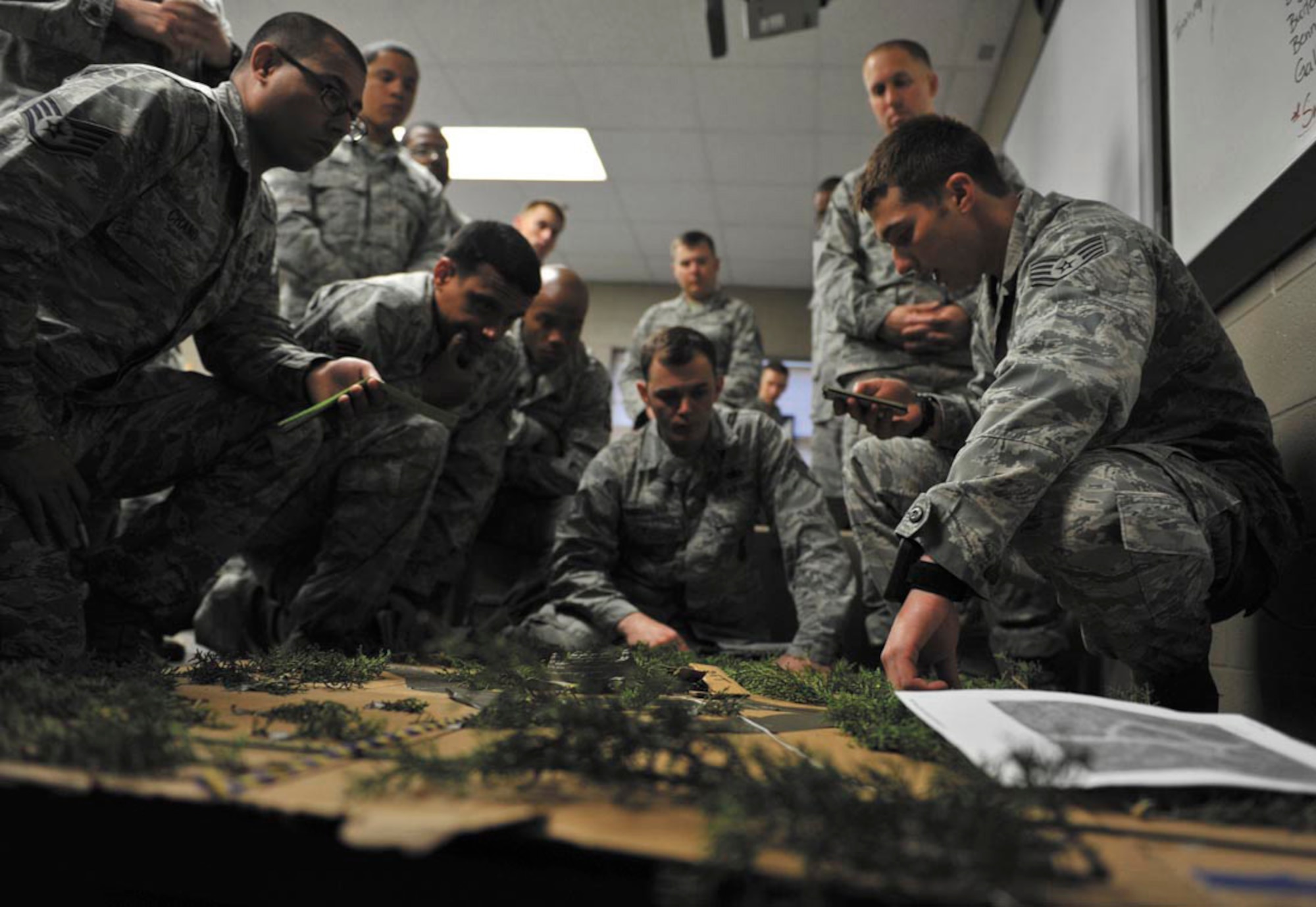 Staff Sgt. Allen Buning, right, a deployed aircraft ground response element team leader with the 1st Special Operations Security Forces Squadron, explains to his squad the initial plan for an assault during their first training mission. Buning and his squad spent 26 days in February attending the Combat Leadership Course, Level II, at Joint Base San Antonio-Camp Bullis, Texas. He and 42 Security Forces Airmen spent the six weeks learning Security Forces operations and practical field skills such as moving as teams and squads, as well as conducting missions in the field. The course is taught several times during the year through the Security Forces Academy, part of the 343rd Training Squadron at JBSA-Lackland. (U.S. Air Force photo by Senior Airman Matthew Fredericks/Released)