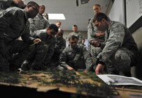 Staff Sgt. Allen Buning, right, a deployed aircraft ground response element team leader with the 1st Special Operations Security Forces Squadron, explains to his squad the initial plan for an assault during their first training mission. Buning and his squad spent 26 days in February attending the Combat Leadership Course, Level II, at Joint Base San Antonio-Camp Bullis, Texas. He and 42 Security Forces Airmen spent the six weeks learning Security Forces operations and practical field skills such as moving as teams and squads, as well as conducting missions in the field. The course is taught several times during the year through the Security Forces Academy, part of the 343rd Training Squadron at JBSA-Lackland. (U.S. Air Force photo by Senior Airman Matthew Fredericks/Released)