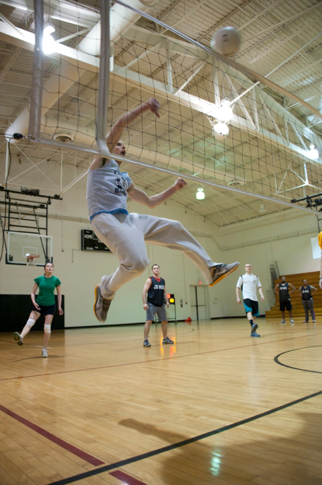 Senior Airman Christopher Bogenschutz, 87th Communications Squadron cyber systems and network operations specialist, spikes a volleyball over a net Feb. 26, 2013, at the McGuire Fitness Center on Joint Base McGuire-Dix-Lakehurst, N.J. The 87th CS-B Team defeated the 87th Wing Staff Agency. (U.S. Air Force photo by Airman Sean M. Crowe/Released)