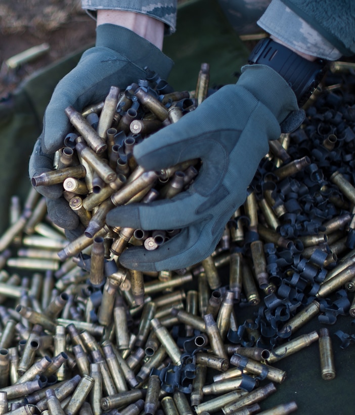 An 11th Security Forces Group Airman cleans up spent shell casings during heavy weapons qualification Mar. 4, 2013, at Marine Corps Base Quantico firing range, Quantico, Va. The SF Airmen shot more than 18,000 rounds for training. (U.S. Air Force photo/Staff Sgt. Perry Aston)