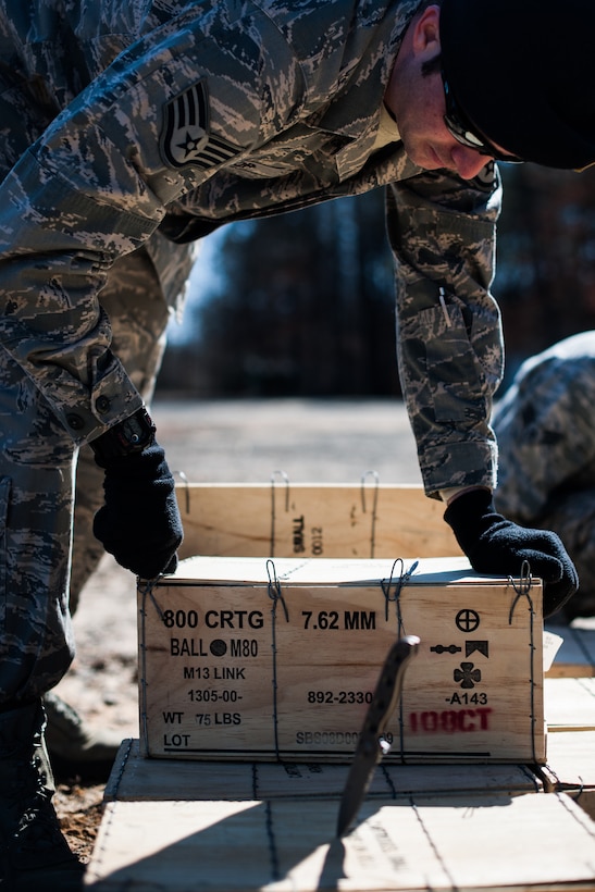 An 11th Security Forces Group Airman opens a box of 7.62mm ammunition for a M240B Medium Machine Gun for heavy weapons qualification Mar. 4, 2013, at Marine Corps Base Quantico firing range, Quantico, Va. Airmen from the 11th SFG qualified on the M240B, Squad Automatic Weapon, and the M203 grenade launcher. (U.S. Air Force photo by Staff Sgt. Perry Aston)