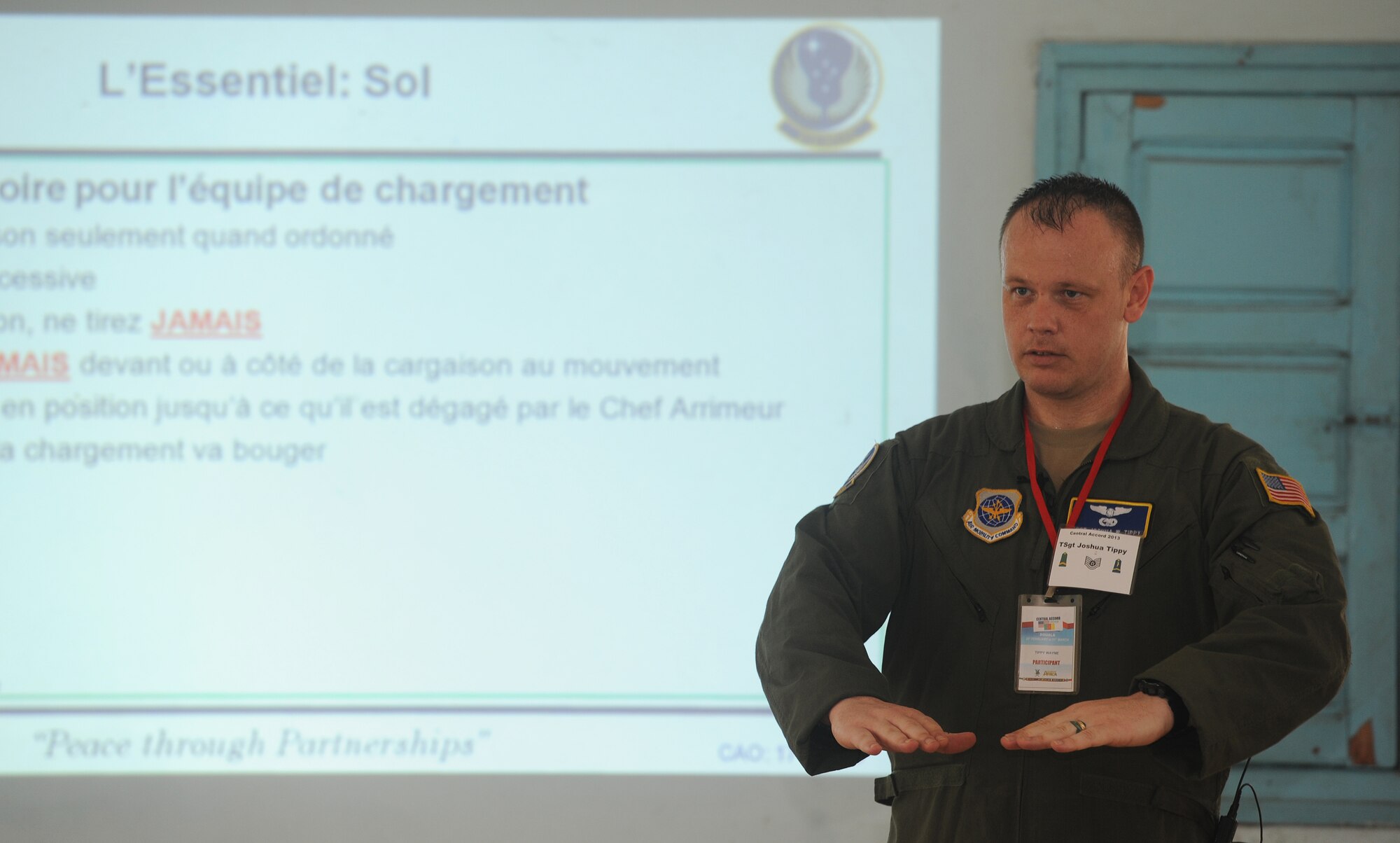 Tech. Sgt. Joshua Tippy, 818th Mobility Support Advisory Squadron loadmaster air adviser from Joint Base McGuire-Dix-Lakehurst, N.J., discusses loadmaster operations with Cameroon Air Force personnel Feb. 21, 2013, at Douala Air Force Base, Douala, Cameroon. Tippy is participating in Central Accord 2013, a joint exercise in which U.S., Cameroon and neighboring Central African militaries partner to promote regional cooperation while increasing aerial resupply and medical readiness capacity. (U.S. Air Force photo by Master Sgt. Stan Parker/Released)