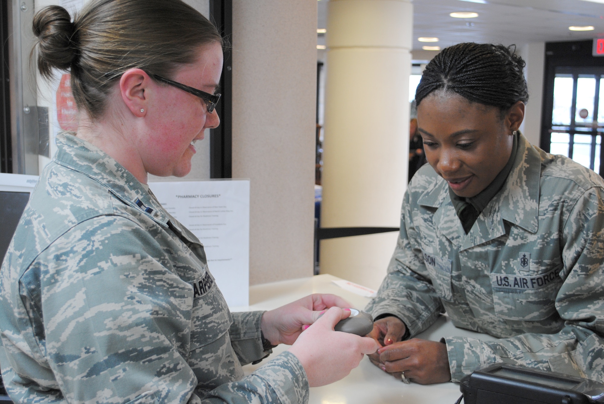 Capt. Julie Carpenter, 341st Medical Group pharmacist, left, shows Tech. Sgt. Shontell Nelson, 341st Medical Support Squadron flight chief, the proper way to use an inhaler.  Carpenter’s job, as well as the other pharmacy members, consists mainly of “behind-the-scenes” work, which she doesn’t mind because she says all work helps the entire Biomedical Services Corps develop one single voice.  (U.S. Air Force photo/Senior Airman Cortney Paxton)