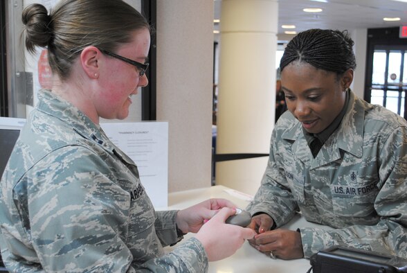 Capt. Julie Carpenter, 341st Medical Group pharmacist, left, shows Tech. Sgt. Shontell Nelson, 341st Medical Support Squadron flight chief, the proper way to use an inhaler.  Carpenter’s job, as well as the other pharmacy members, consists mainly of “behind-the-scenes” work, which she doesn’t mind because she says all work helps the entire Biomedical Services Corps develop one single voice.  (U.S. Air Force photo/Senior Airman Cortney Paxton)