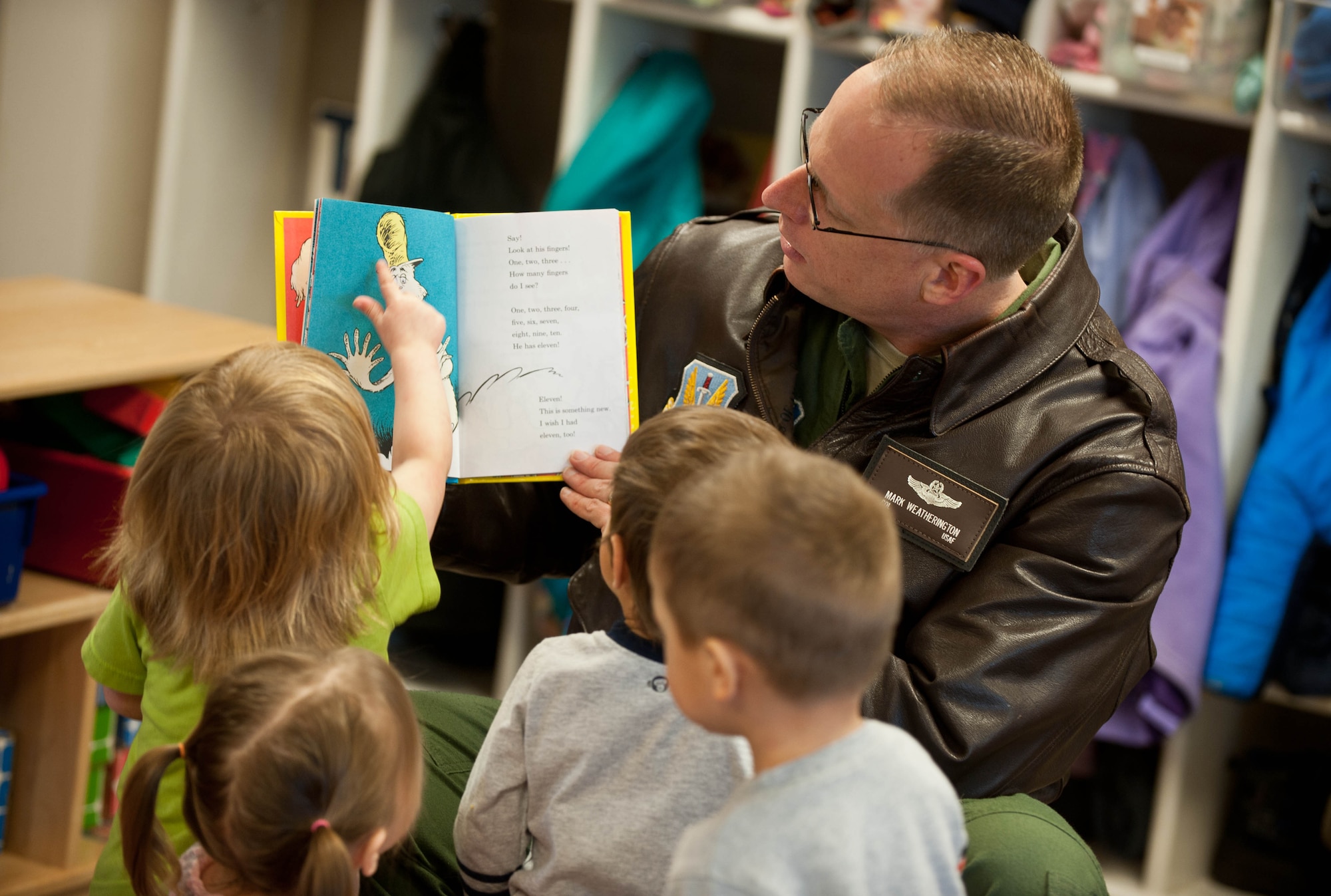 Col. Mark Weatherington, 28th Bomb Wing commander, reads “One Fish, Two Fish, Red Fish, Blue Fish” to a group of 2-year-old children during a Read Across America event at the Child Development Center at Ellsworth Air Force Base, S.D., March 1, 2013. Ellsworth Airmen participated in Read Across America, observed annually on Dr. Seuss’ birthday, by reading his books to children and promoting literacy for children. (U.S. Air Force photo by Airman 1st Class Zachary Hada/Released)
