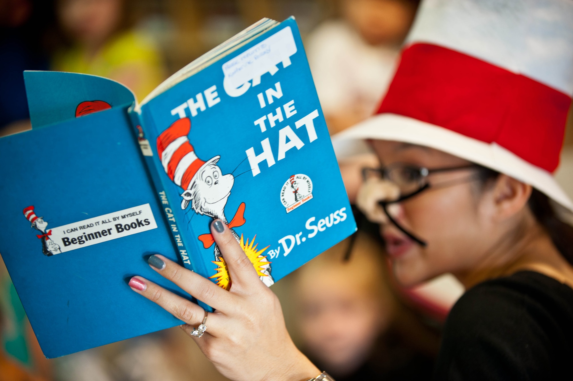 Eva Burley, reads “The Cat in the Hat” to a group of 3-to-5-year-old children during a Read Across America event at the Child Development Center at Ellsworth Air Force Base, S.D., March 1, 2013. The event features volunteers reading books to children to promote reading. (U.S. Air Force photo by Airman 1st Class Zachary Hada/Released)