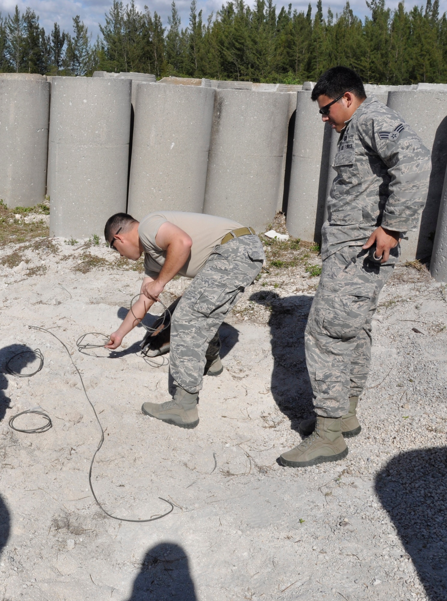Master Sgt. Jessie Barcala and Senior Airman Fernando Olivias Fortin, both of the 482nd Civil Engineering Squadron Explosive Ordnance Disposal flight, set up an explosive branch line to attach to an explosive main line used to set off multiple explosives at Homestead Air Reserve Base, Fla., Feb. 9. EOD neutralizes used and unused ordnance that remain after an incident, accident, or enemy attack which presents a threat to military operations, installations, personnel or material. They tackle a range of contingencies from neutralizing explosives and bombs, to recovering found ordnance, and supporting the secret service, aircraft crashes, incident response teams, and post attack base recovery operations. (U.S. Air Force photo/Senior Airman Nicholas Caceres)