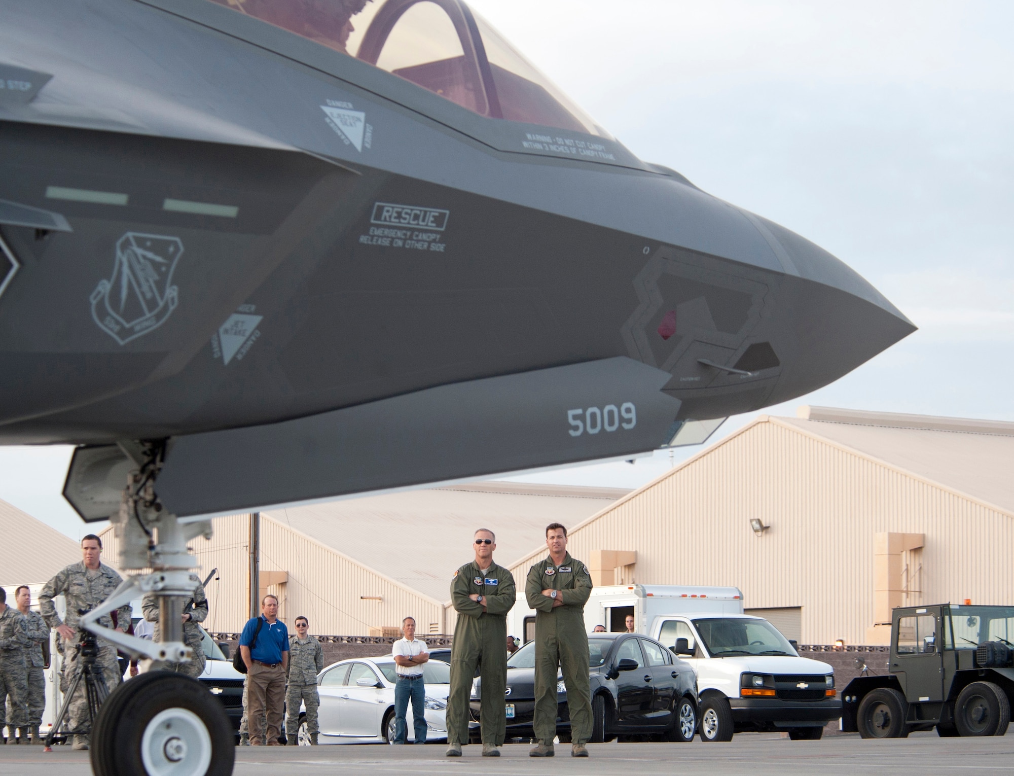 (To the right of the nose gear) Maj. Gen. Jeff Lofgren (left), U.S. Air Force Warfare Center commander, and Brig. Gen. Charles Moore (right), 57th Wing commander, wait to greet the pilots of the two F-35 Lighting IIs that arrived at Nellis Air Force Base, Nev., March 6, 2013. The aircraft are assigned to the 422nd Test and Evaluation Squadron and its modern engine delivers more than 60 percent more thrust than other aircraft of the same weight.
(U.S. Air Force photo by Lawrence Crespo)
