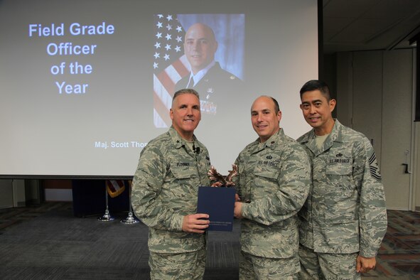 Brig. Gen. Jay Flournoy, Air Reserve Personnel Center commander, and Chief Master Sgt. Brian Wong, ARPC command chief, present the ARPC Field Grade Officer of the Year award to Maj. Scott Thomason. Flournoy honored ARPC's 2012 Outstanding Performers of the Year as well as their A1 annual award winners during commander's call March 6, 2013, on Buckley Air Force, Colo. (U.S. Air Force photo/Tech. Sgt. Rob Hazelett)