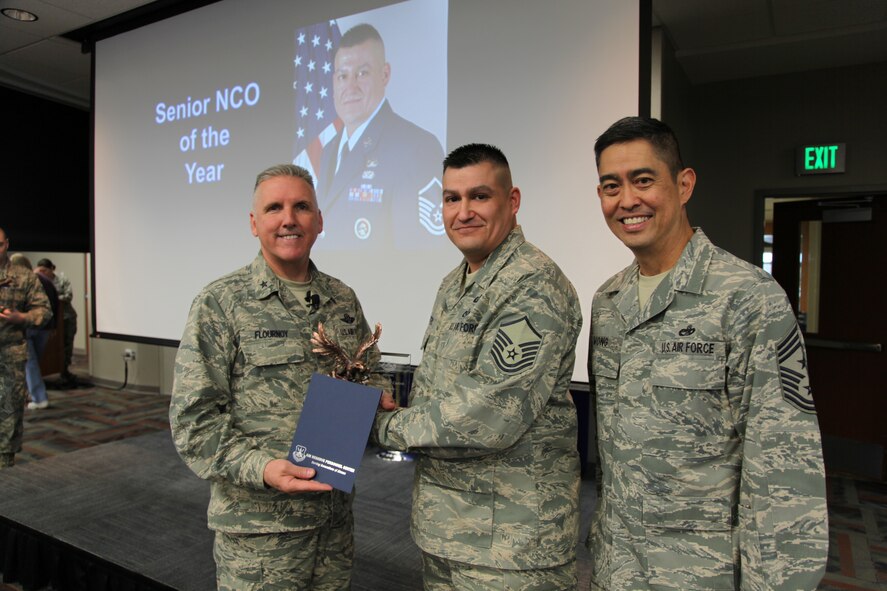 Brig. Gen. Jay Flournoy, Air Reserve Personnel Center commander, and Chief Master Sgt. Brian Wong, ARPC command chief, present the ARPC SNCO of the Year award to Master Sgt. Javier Castro. Flournoy honored ARPC's 2012 Outstanding Performers of the Year as well as their A1 annual award winners during commander's call March 6, 2013, on Buckley Air Force, Colo. (U.S. Air Force photo/Tech. Sgt. Rob Hazelett)