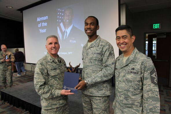 Brig. Gen. Jay Flournoy, Air Reserve Personnel Center commander, and Chief Master Sgt. Brian Wong, ARPC command chief, present the ARPC Airman of the Year award to Senior Airman Sean Cooper. Flournoy honored ARPC's 2012 Outstanding Performers of the Year as well as their A1 annual award winners during commander's call March 6, 2013, on Buckley Air Force, Colo. (U.S. Air Force photo/Tech. Sgt. Rob Hazelett)