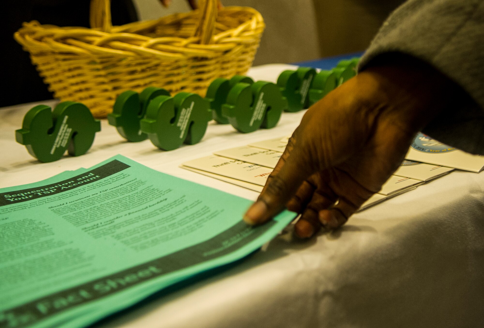 Air Force District of Washington civilians pick up informational materials prior to a town hall meeting hosted by AFDW Commander Maj. Gen. Sharon K.G. Dunbar March 5, 2013 at Joint Base Andrews, Md., theater.  The meeting discussed sequestration and furlough and the effects it will have on AFDW. (U.S. Air Force photo by 1st Lt. Ashleigh Peck)