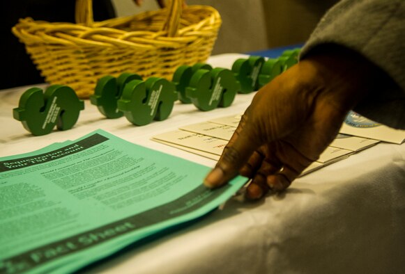 Air Force District of Washington civilians pick up informational materials prior to a town hall meeting hosted by AFDW Commander Maj. Gen. Sharon K.G. Dunbar March 5, 2013 at Joint Base Andrews, Md., theater.  The meeting discussed sequestration and furlough and the effects it will have on AFDW. (U.S. Air Force photo by 1st Lt. Ashleigh Peck)